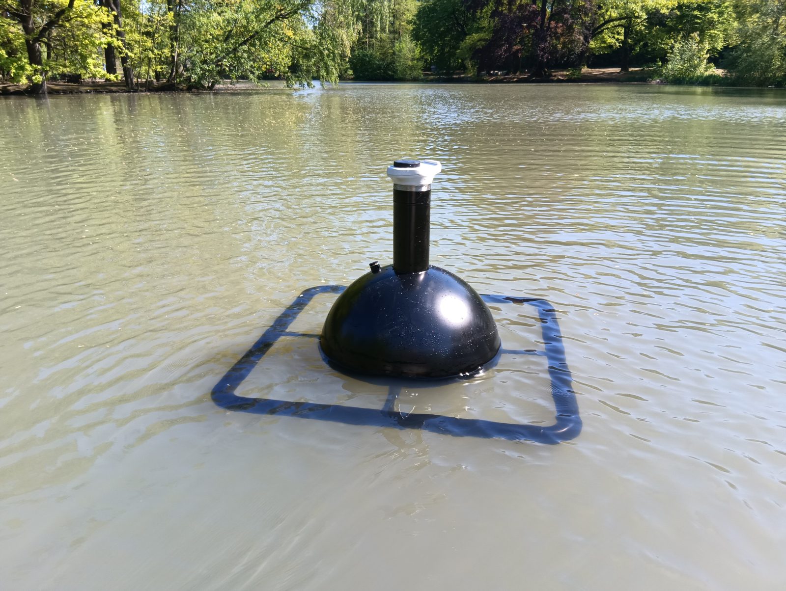 Messboje mit Anti-Kollisionsrahmen auf einem trüben Stadtparkgewässer