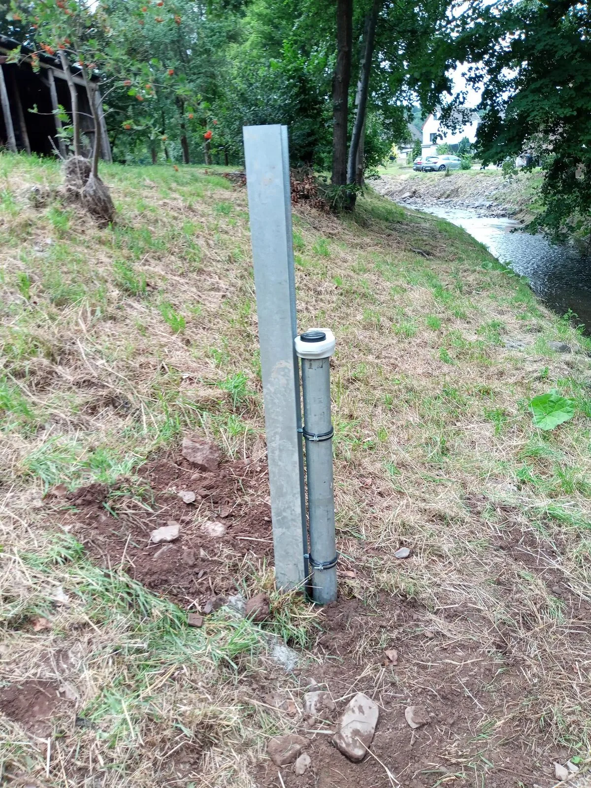 Peilbuis met datalogger aan de oever, dicht bij het meetpunt.