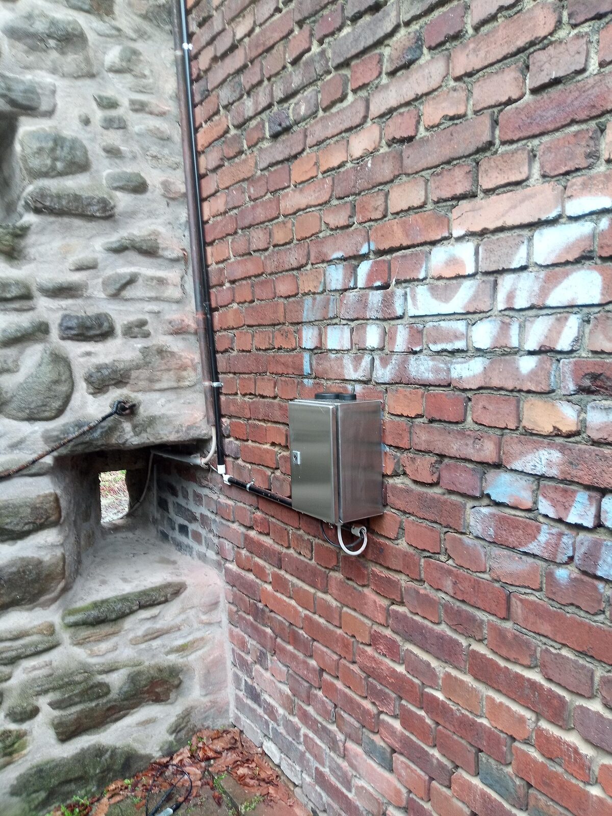 Radarpegel in Edelstahlgehäuse an historischer Bruchsteinmauer