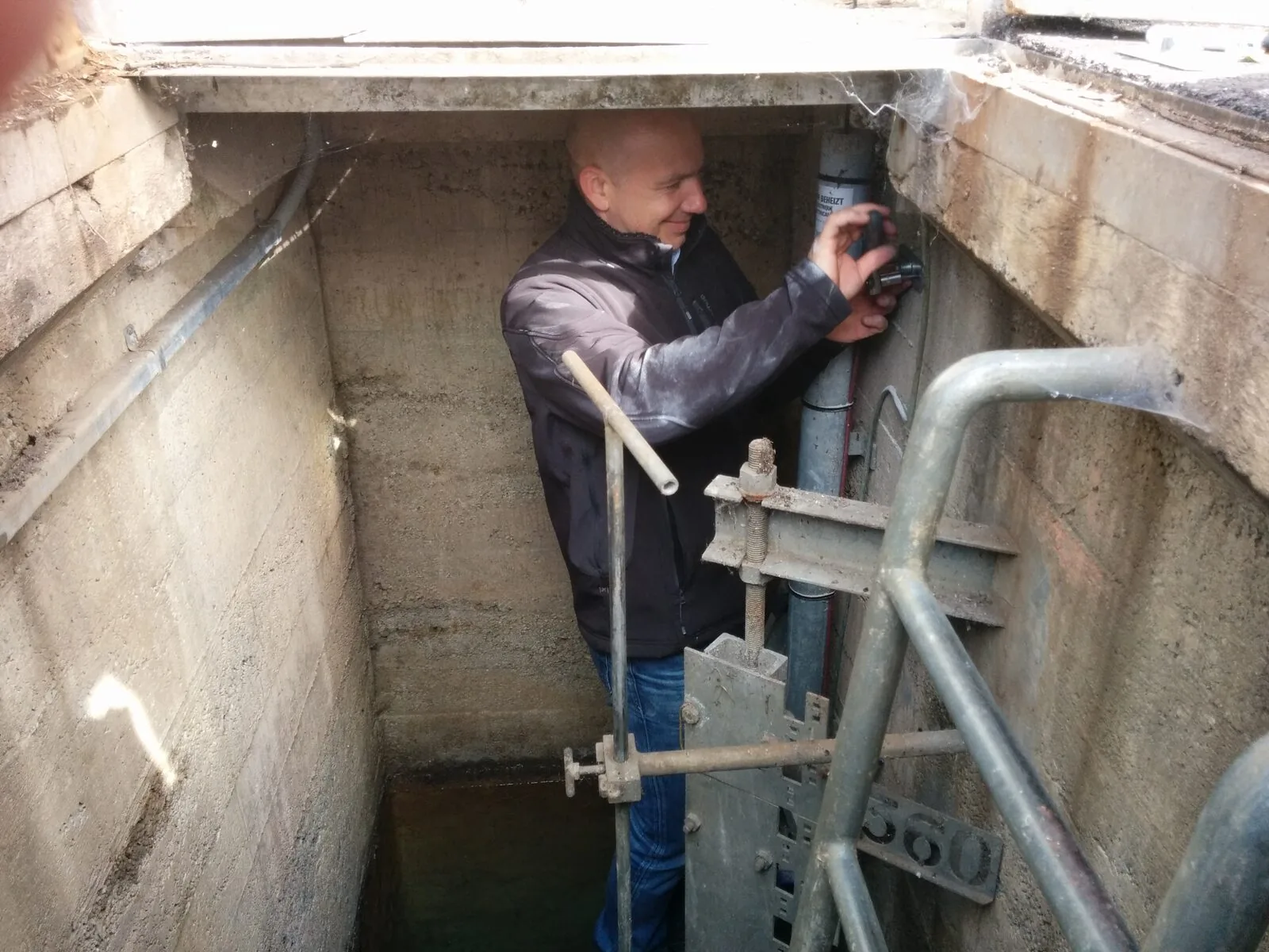Ein Techniker arbeitet an der Messtechnik in einem Schacht.